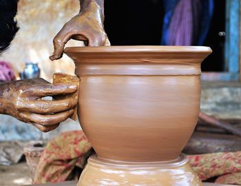 Cropped image of craftperson making pottery