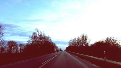 Road amidst trees against sky