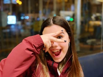 Portrait of smiling girl gesturing over face