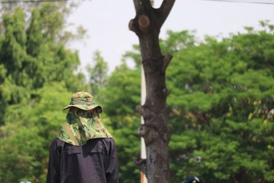 Rear view of man standing against trees