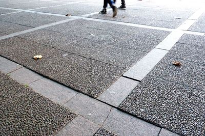 Low section of person walking on road