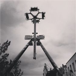 Low angle view of crane against cloudy sky