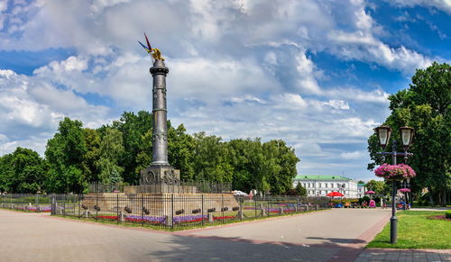 View of monument in city against cloudy sky