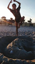 Full length of woman exercising at beach