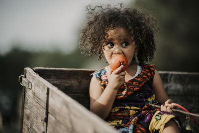 Portrait of cute girl sitting outdoors