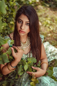 Portrait of young woman sitting on field