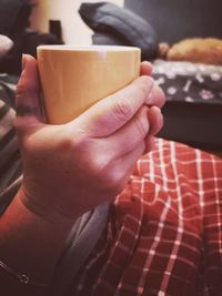 Close-up of hand holding coffee cup