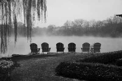 Gazebo on field by lake against sky