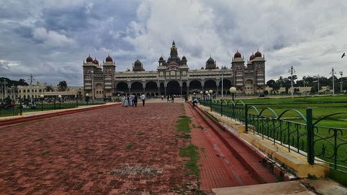 People at town square against cloudy sky