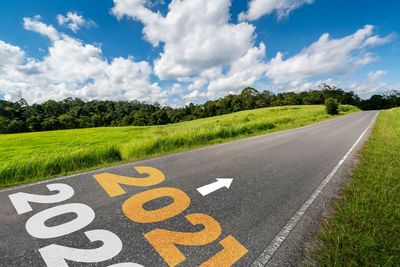 Road sign on land against sky