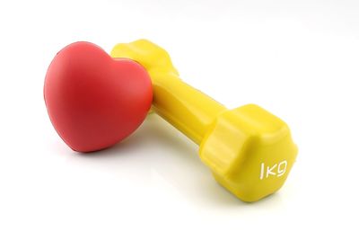 Close-up of multi colored dumbbell on white background