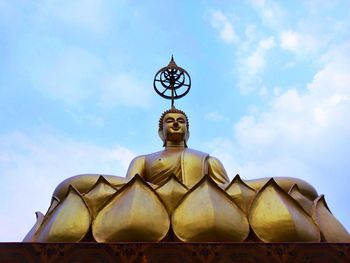 Low angle view of statue against building against sky