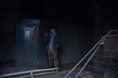 Full length of man smoking cigarette in abandoned room