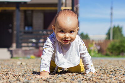 Cute baby boy crawling at playground outdoors
