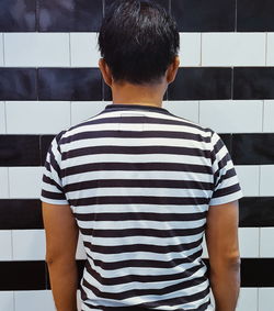 Rear view of man standing against wall