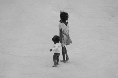 Siblings walking at beach