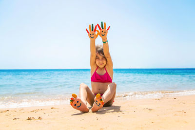 Portrait of smiling girl showing painted hand at beach