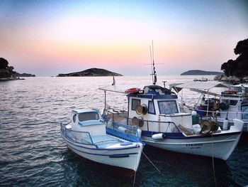 Boats in sea at sunset