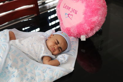 High angle view of baby girl sleeping on table at home