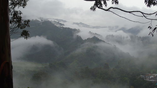 Scenic view of mountains against cloudy sky