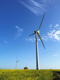 Low angle view of windmill on field against sky