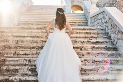 Rear view of woman standing on staircase