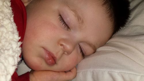 Close-up of baby boy sleeping on bed