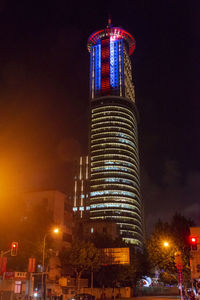 Low angle view of illuminated buildings against sky at night