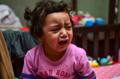 Close-up of girl crying while sitting at home