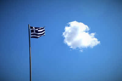 Low angle view of flag against blue sky