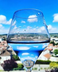 Close-up of beer glass against blue sky