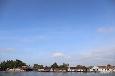 Buildings and trees against blue sky