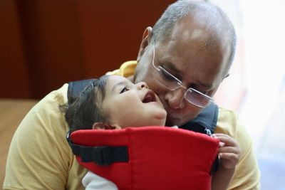 Grandfather kissing cute baby boy