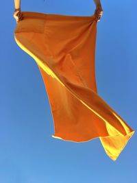 Low angle view of flag against clear blue sky