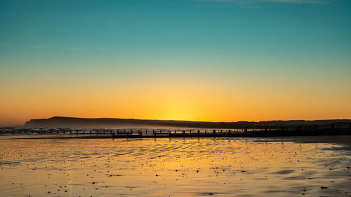 Scenic view of sea against clear sky during sunset