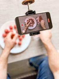 Low angle view of person holding mobile phone on table