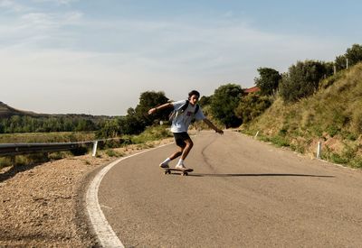 Full length of man skateboarding on road against sky