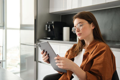 Young woman using mobile phone at home