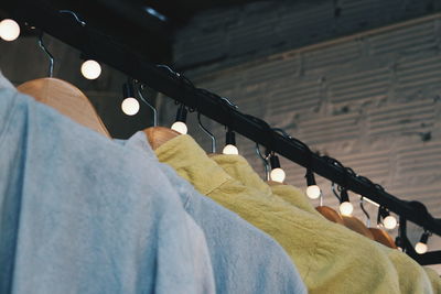 Close-up of clothes hanging on illuminated rack