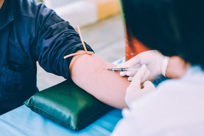 Cropped hands of doctor injecting patient