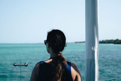 Rear view of woman looking at sea against sky