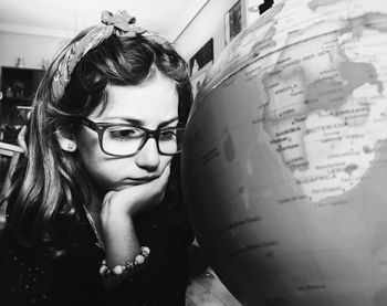 Close-up of little girl looking at globe