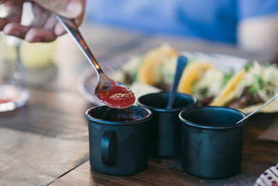 Close-up of hand holding fruit on table