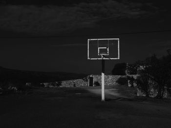 Basketball hoop against sky at night