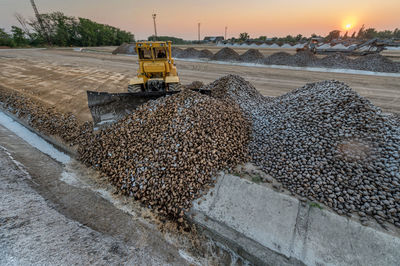 Earth mover at construction site against sky