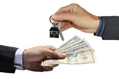 Close-up of hand holding paper over white background