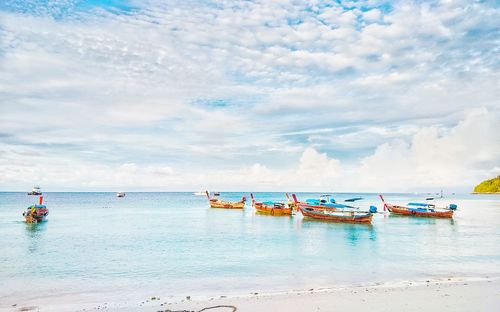 Boats moored in sea against sky