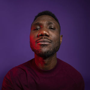 Close-up portrait of young man against gray background