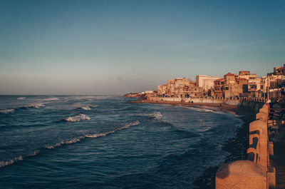 Scenic view of seafront in a small coastal village against sky.