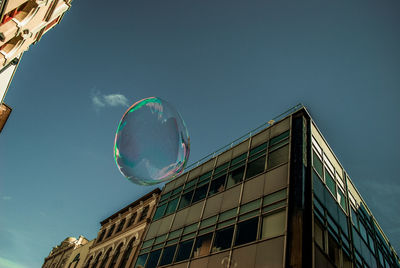 Low angle view of bubble against blue sky during sunny day